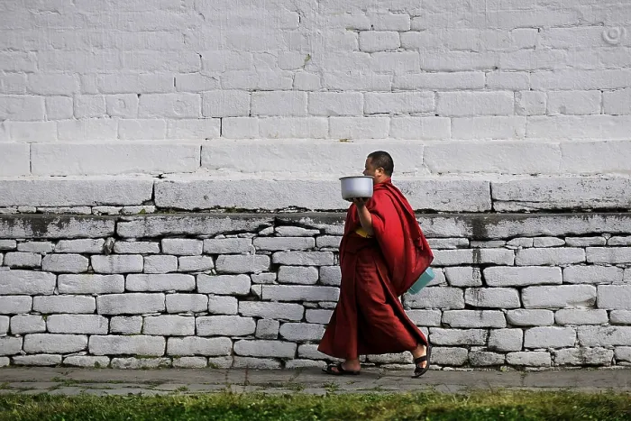 Framed Print : Monk walking through the monastery courtyard in Jampey Lhakhang Temple