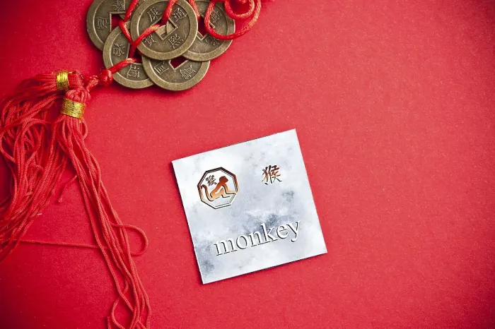 Framed Print : Monkey zodiac card with Chinese character on a red background with coins