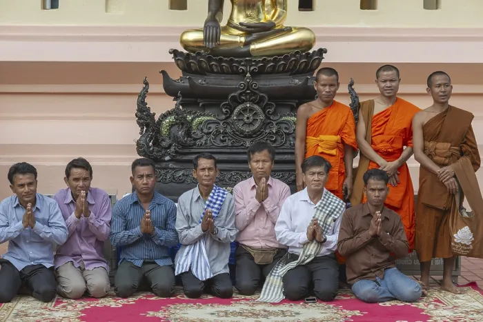 Framed Print : Monks and Laotians in front of a Buddha statue
