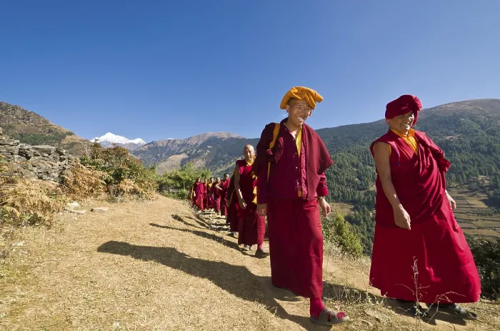 Framed Print : Monks and nuns wearing red cloths walking on a small path along a mountain slope