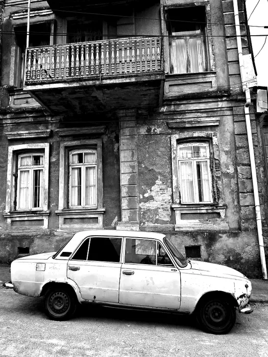 Framed Print : Monochrome, vintage car standing in front of a Nostaligian building with a distinctive balcony