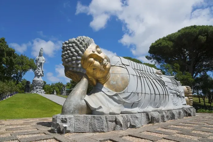 Framed Print : Monumental reclining Buddha statue in a green and peaceful park under a clear blue sky