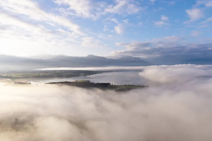 Framed Print : Morning fog hovers over Lake Forggensee with mountains in the background