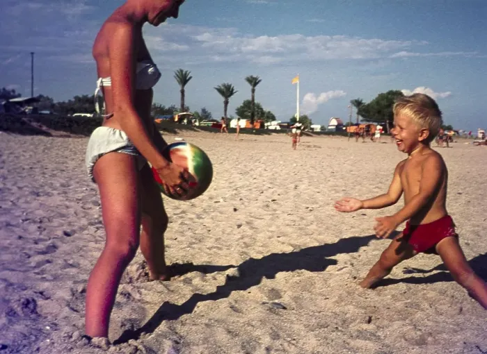 Framed Print : Mother and young son playing catch with a ball on sandy beach in Spain, 1966