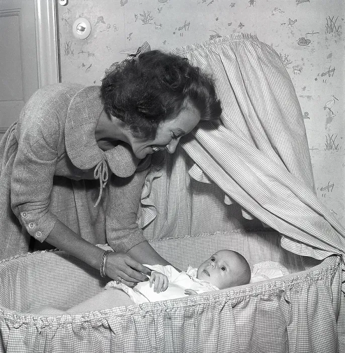 Framed Print : Motherhood in the 1950s. A mother is cuddling with her baby at home