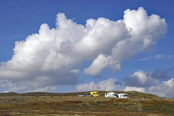 Framed Print : Motorhomes on a hilly landscape under large