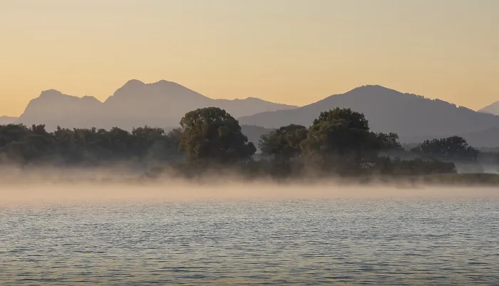 Framed Print : Mountain backdrop (Chiemgau Alps) and trees on the tranquil Chiemsee during sunrise