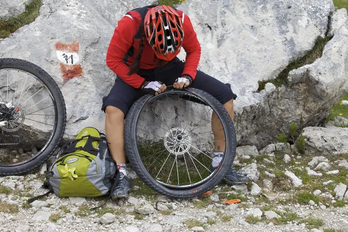 Framed Print : Mountain bike rider repairing a flat front tyre