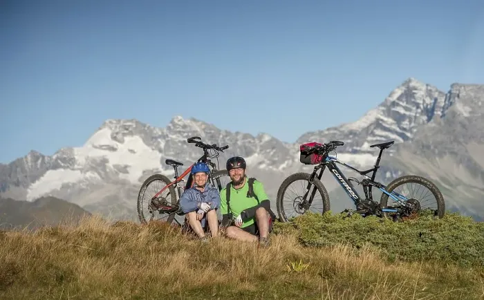 Framed Print : Mountain biker couple sitting next to eBikes in the autumnal mountain scenery of the Stubaier Alps