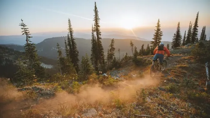 Framed Print : Mountain biker descending a forest trail at sunset, surrounded by trees and raising dust, Baldy Mountain, Nelson, BC, Canada, North America