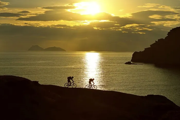 Framed Print : Two mountain bikers cycling on a rocky coast