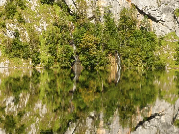 Framed Print : Mountain forest, small waterfall and rock walls are reflected in Obersee