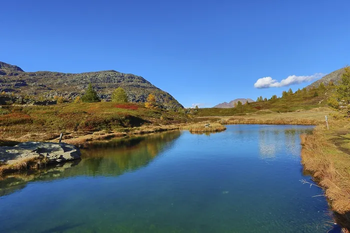 Framed Print : Mountain lake with calm water and surrounding hills under a cloudless sky