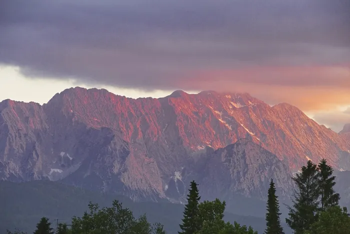 Framed Print : Mountain peak in bright red at sunset with dramatic clouds in the sky