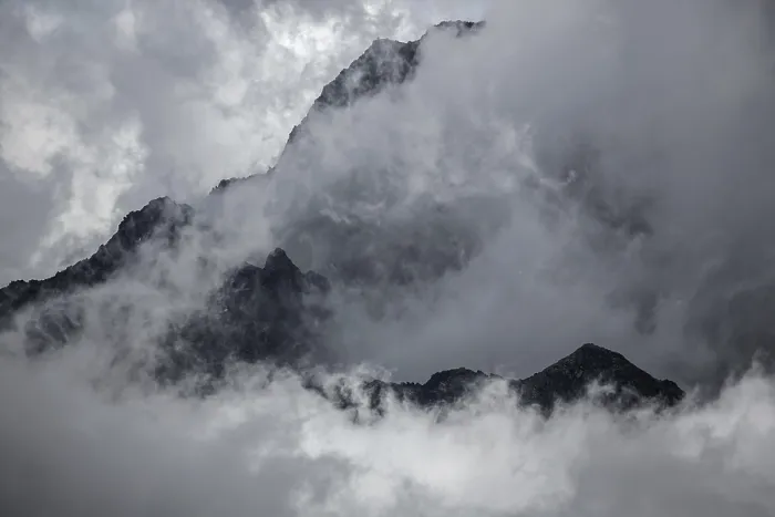 Framed Print : Mountain peak rises out of clouds