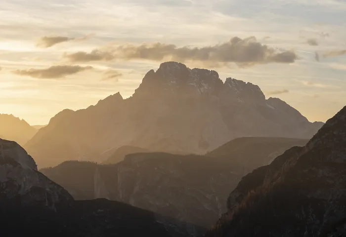Framed Print : Mountain silhouette during sunset with dramatic clouds and warm light in alpine terrain