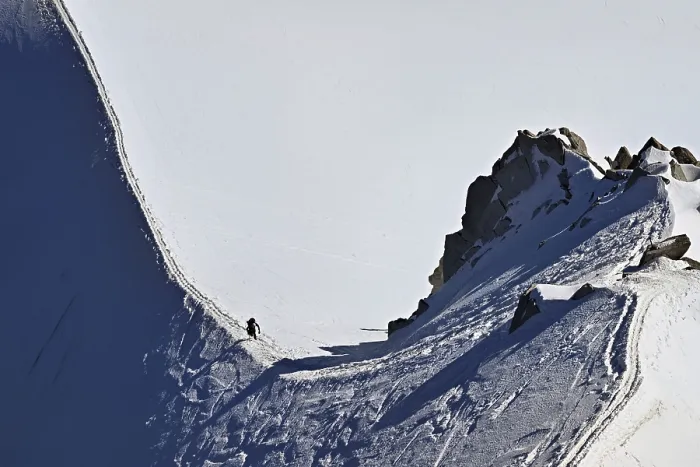 Framed Print : A mountaineer climbs over a snow-covered mountain ridge Framed Print : A mountaineer climbs over a snow-covered mountain ridge