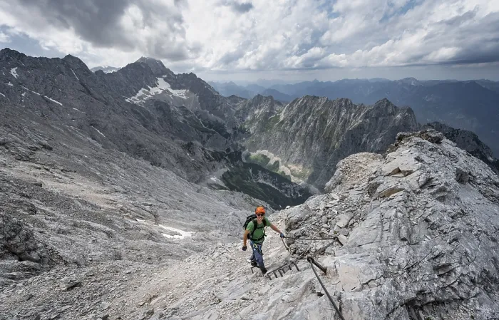 Framed Print : Mountaineer with helmet climbing on rock