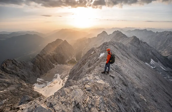 Framed Print : Mountaineer with helmet on a narrow rocky ridge at sunrise