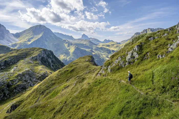 Framed Print : Mountaineer on a hiking trail on a grassy mountain ridge
