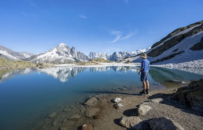 Framed Print : Mountaineer in front of mountain landscape with mountain lake Framed Print : Mountaineer in front of mountain landscape with mountain lake