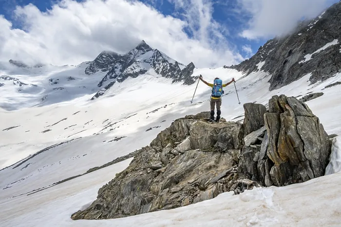 Framed Print : Mountaineer on a rock between snow