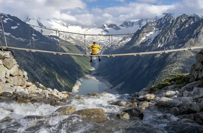 Framed Print : Mountaineer sitting on a suspension bridge over a mountain stream Alelebach