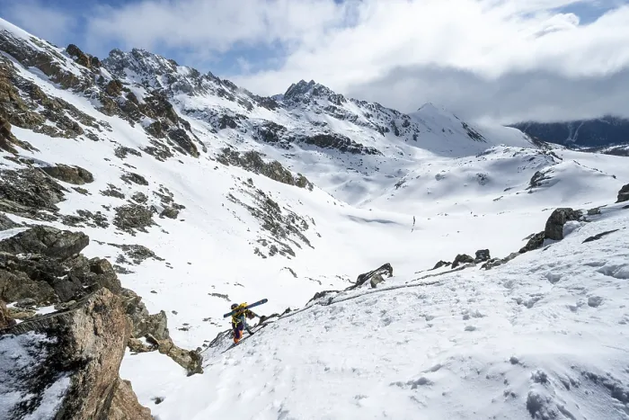 Framed Print : Mountaineer with skis climbing up a steep snow slope to the fork Porta d'Es-cha