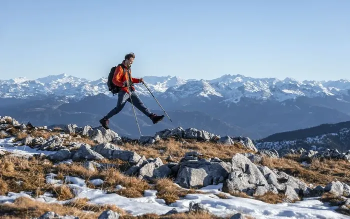 Framed Print : Mountaineer taking a big step, in front of mountain panorama