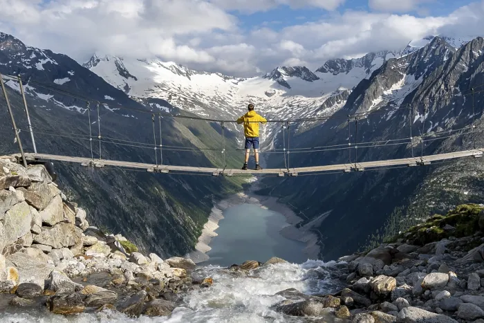 Framed Print : Mountaineers on a suspension bridge over a mountain stream Alelebach