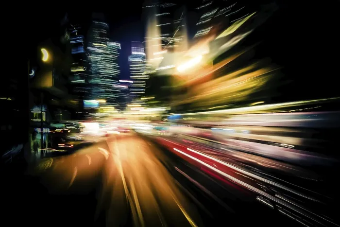 Framed Print : Moving through modern city street with illuminated skyscrapers