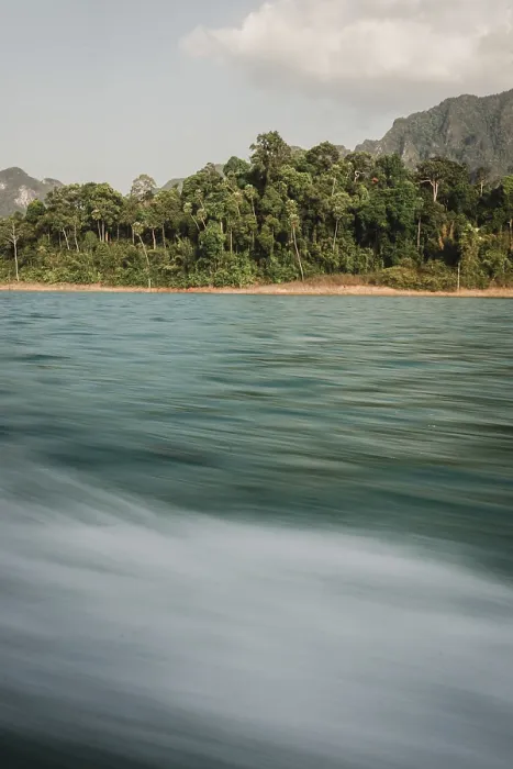 Framed Print : Moving water in front of a picturesque coastline with forest in the background Framed Print : Moving water in front of a picturesque coastline with forest in the background