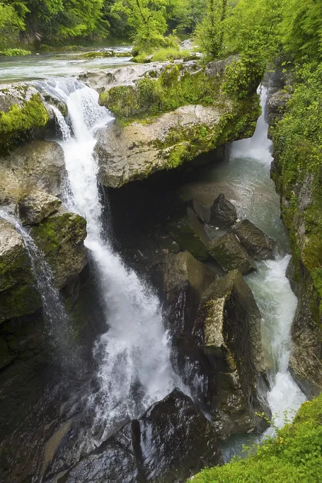 Framed Print : Narrow waterfall through deep gorge surrounded by thick greenery