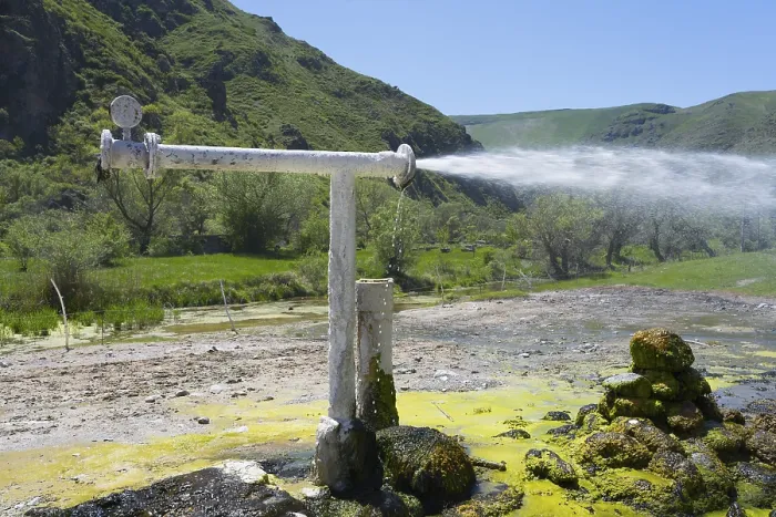 Framed Print : Natural water source with sparkling water jet against green mountain landscape