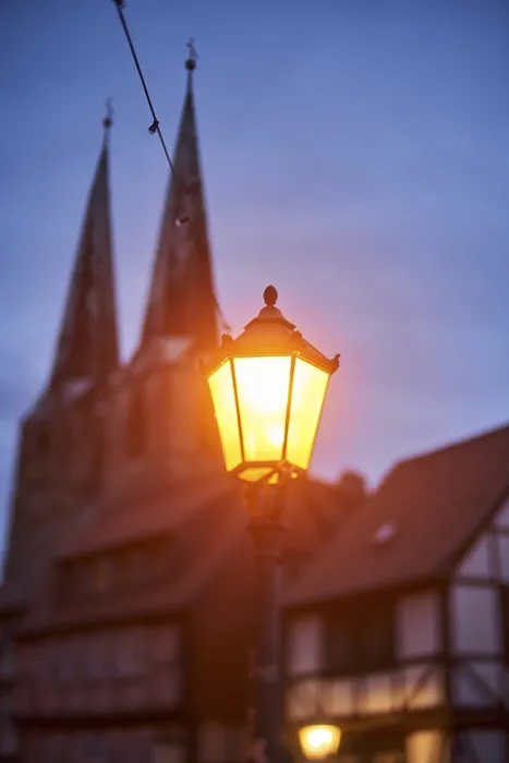 Framed Print : Nocturnal street lamp glows in the dark blue hour in front of St