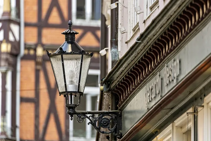 Framed Print : Nostalgic lantern next to a building in front of half-timbered buildings and windows in urban space