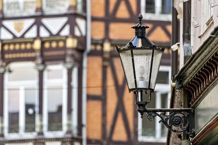 Framed Print : Nostalgic lantern in front of a half-timbered house with traditional architectural elements Framed Print : Nostalgic lantern in front of a half-timbered house with traditional architectural elements