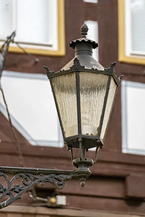 Framed Print : Nostalgic lantern in front of a half-timbered house with windows in a traditional cityscape Framed Print : Nostalgic lantern in front of a half-timbered house with windows in a traditional cityscape