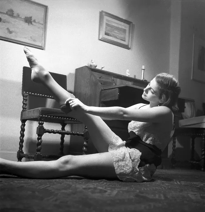 Framed Print : Nylon stockings in the 1940s. A young woman is getting dressed in the moring Framed Print : Nylon stockings in the 1940s. A young woman is getting dressed in the moring