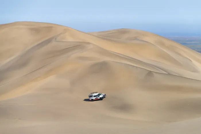 Framed Print : Off-road vehicle in sand dunes above the Orange River