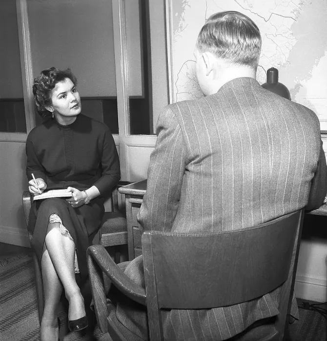 Framed Print : Office girl in the 1950s. A woman is sitting with a notebook in her lap writing notes of what the man says, possibly a letter that she later will type. To have a secretary was more common in the past then today Framed Print : Office girl in the 1950s. A woman is sitting with a notebook in her lap writing notes of what the man says, possibly a letter that she later will type. To have a secretary was more common in the past then today