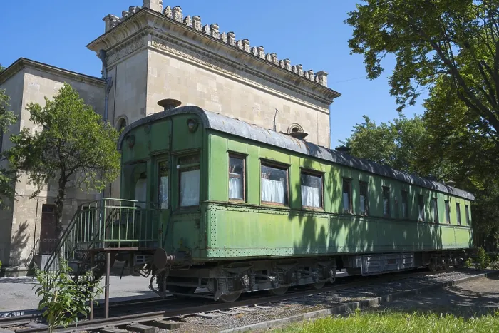 Framed Print : Old green railroad car in front of historic building and trees Framed Print : Old green railroad car in front of historic building and trees
