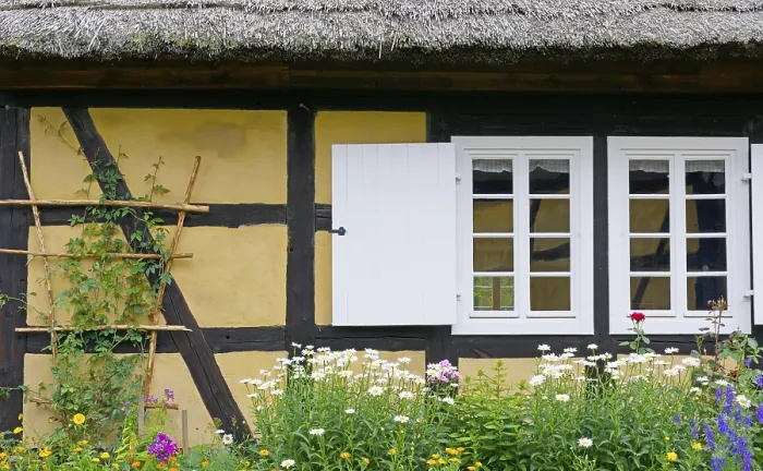 Framed Print : An old half-timbered house with flowers in front of it
