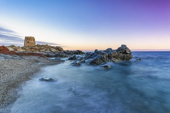 Framed Print : Old historic tower from the 16th century and rocks at sunset on the beach
