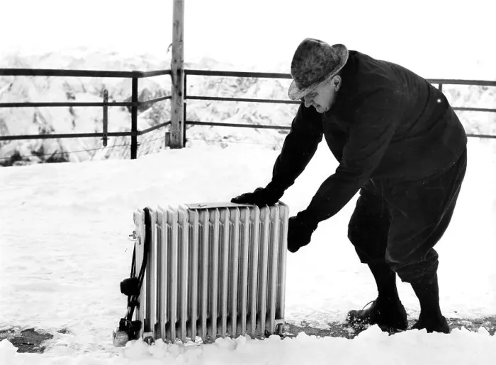 Framed Print : Old man pushes radiator through snow