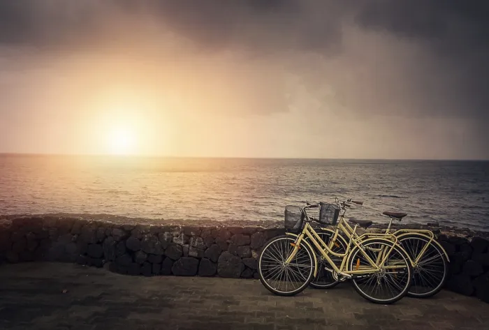 Framed Print : Two old retro vintage bicycles rested on a stone wall on the seaside in Lanzarote