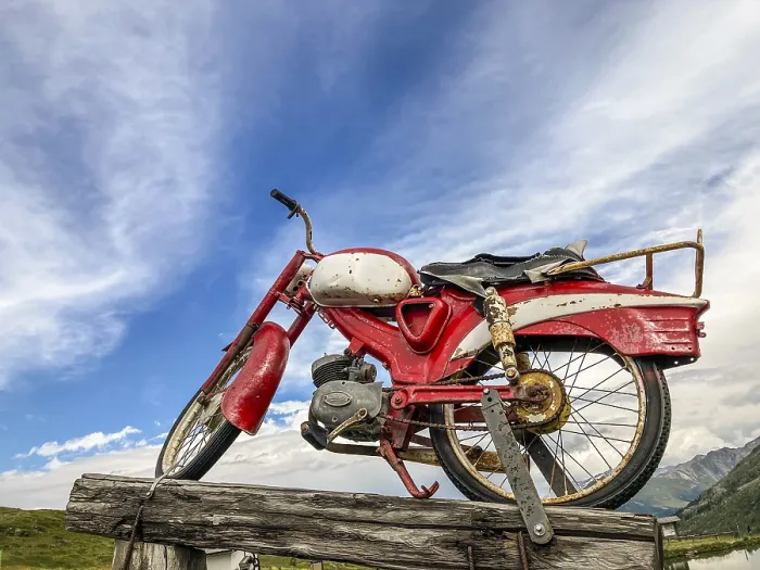 Framed Print : An old rusty red motorcycle stands on a wooden pole