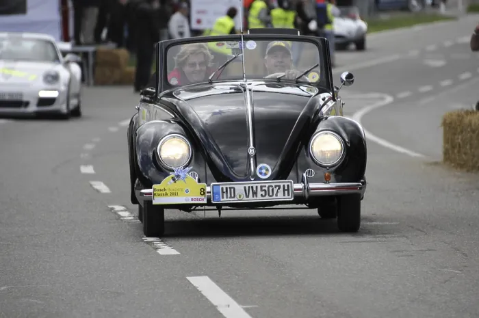 Framed Print : An old Volkswagen Beetle convertible drives past spectators at a car race Framed Print : An old Volkswagen Beetle convertible drives past spectators at a car race