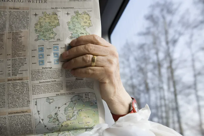 Framed Print : Old woman passenger reading newspaper in German rail journey