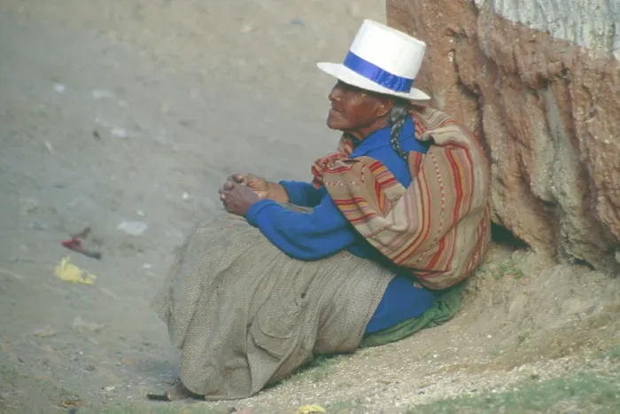 Framed Print : Old woman sitting on the side of the road